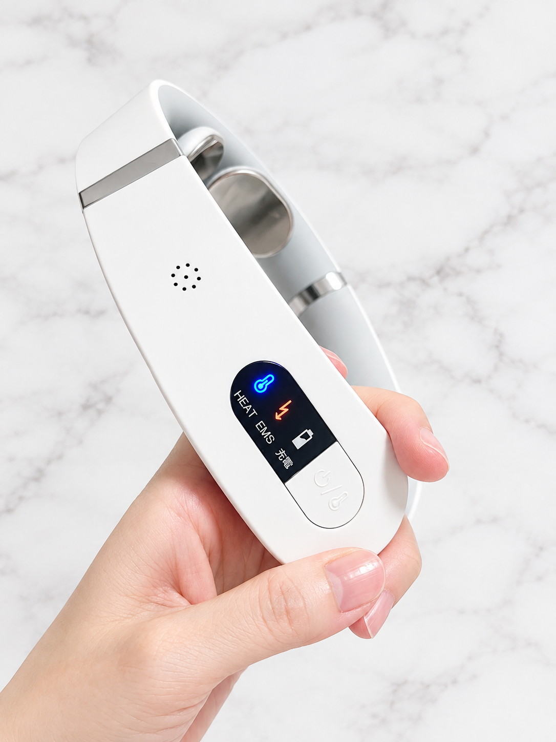 MYTREX EMS ヒートネックを手に持ったところ。HEAT・EMS・充電のランプが点灯している操作部